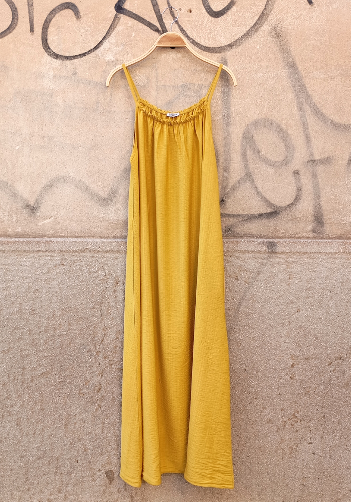 Κίτρινο maxi φόρεμα με λεπτές τιράντες και σούρα στο μπούστο, ιδανικό για καλοκαιρινές εμφανίσεις.
